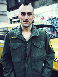 Photo from the movie Taxi Driver showing actor Robert De Niro portraying psycho killer Travis Bickle. In this photo Bickle is wearing an Army jacket and his hair is cut in a Mohawk.