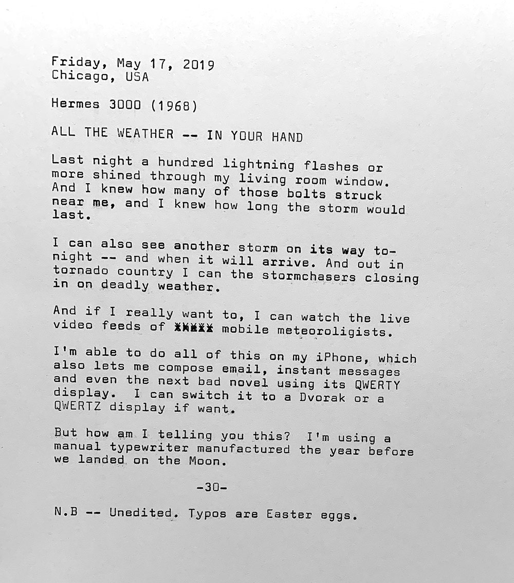 This photo is of a typewritten page with the following text. Friday, May 17, 2019. Chicago, USA. Hermes 3000. All the weather — right in your hand. Last night a hundred lightning flashes or more shined through my living room window. And I knew how many of those bolts struck near me, and I knew how long the storm would last. I can also see another storm on its way to— night — and when it will arrive. And out in tornado country I can the stormchasers closing in on deadly weather. And if I really want to, I can watch the live video feeds of mobile meteorologists. I’m able to do all of this on my iPhone, which also lets me compose email, instant messages and even the next bad novel using its QWERTY display. I can switch it to a Dvorak or a QWERTZ display if want. But how am I telling you this? I’m using a manual typewriter manufactured the year before we landed on the Moon. Note: This typecast is unedited. Typos are Easter eggs.