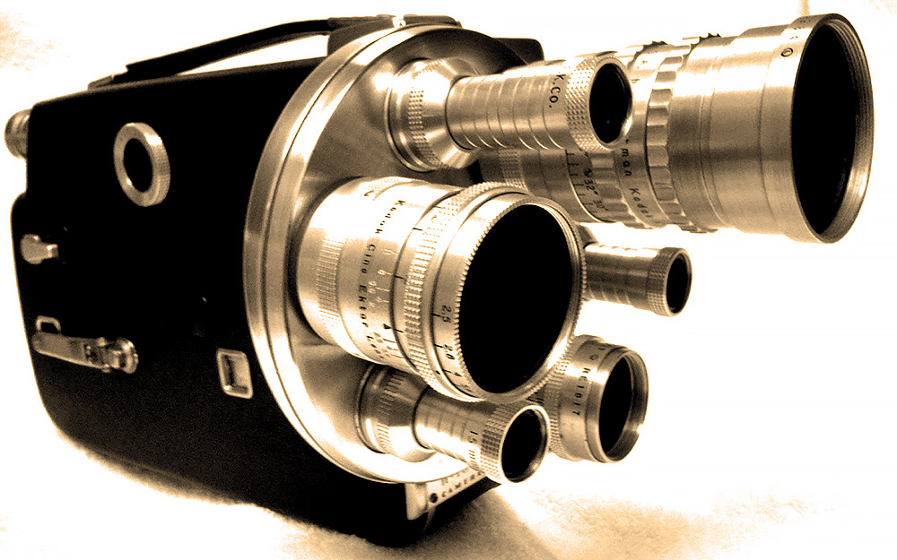 Photo of a 1950s-era Cine-Kodak K-100 turret movie camera. This 16mm camera has three lenses on front and a leather-and-polished aluminum body.